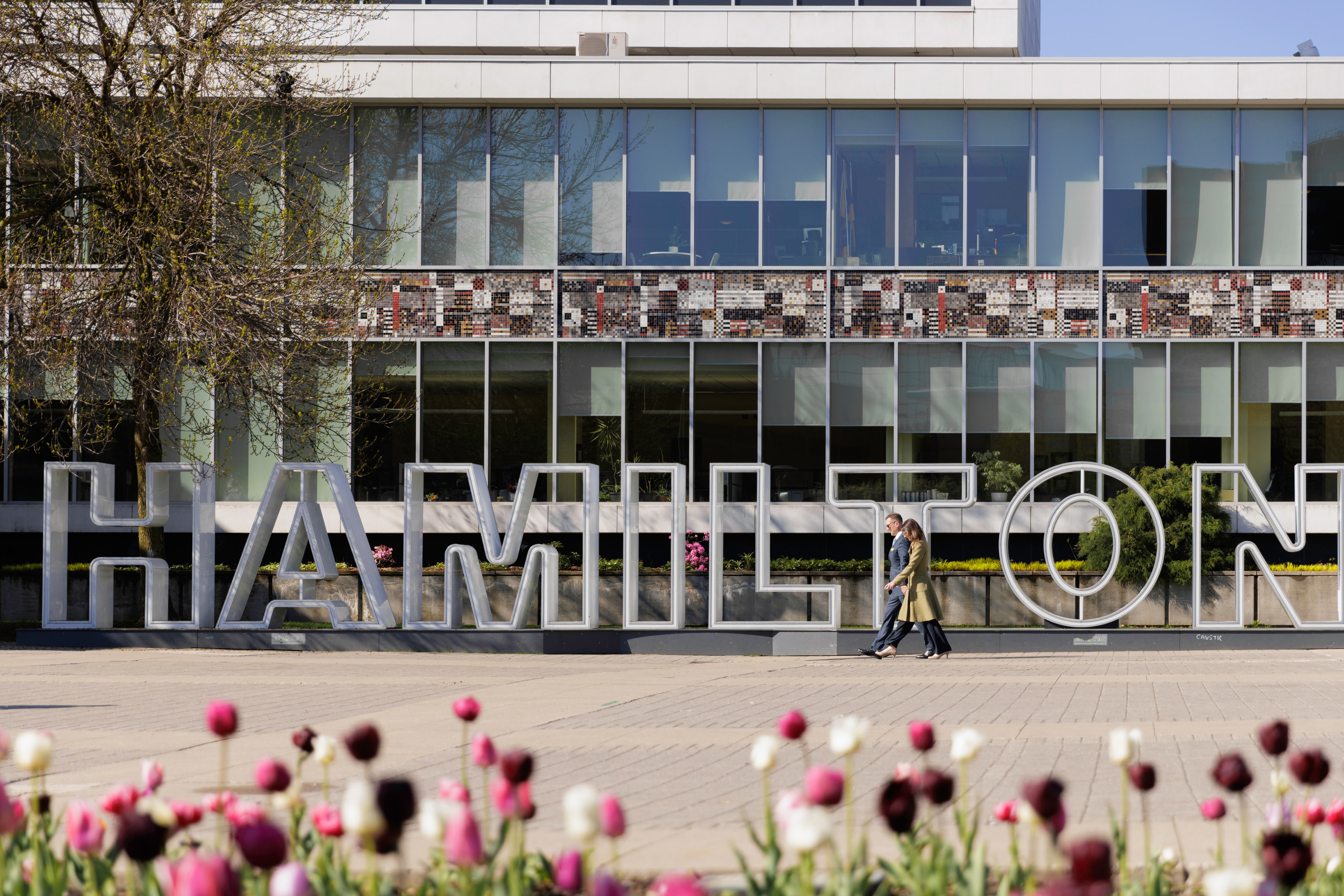 Keanin & Trish Walking in front of Hamilton Sign.